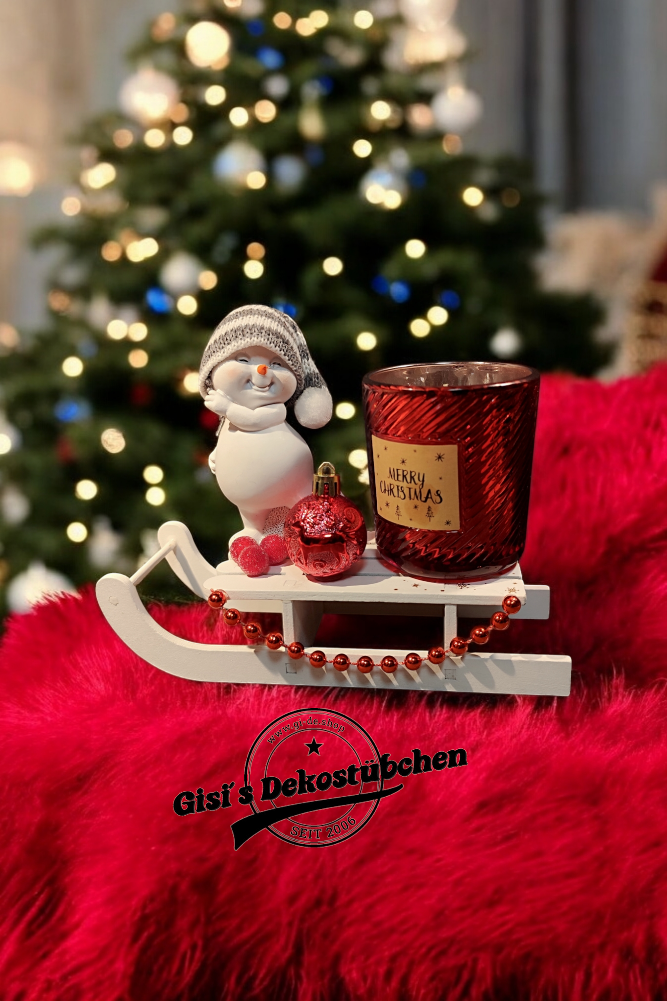 Weihnachtsdeko mit Schlitten, Schneemann, Kerze, Christbaumkugel Rot
