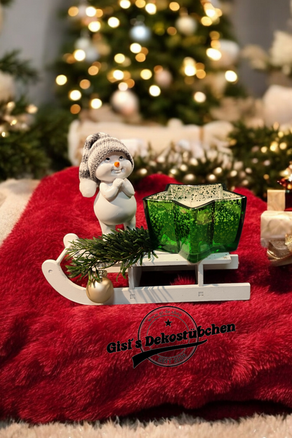 Weihnachtsdeko mit Schlitten, Schneemann, Kerze, Tannenzweige, Christbaumkugel Grün