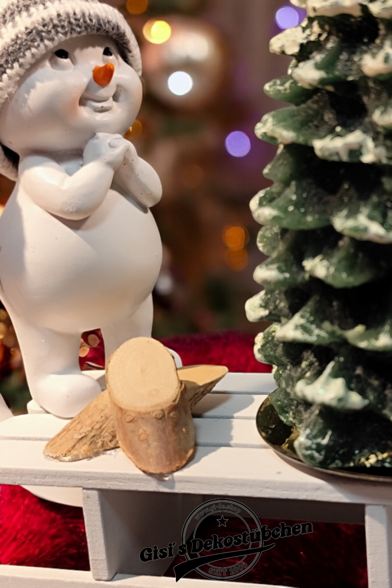 Weihnachtsdeko mit Schlitten, Schneemann, Tannebaumkerze und Holzscheiben Grün