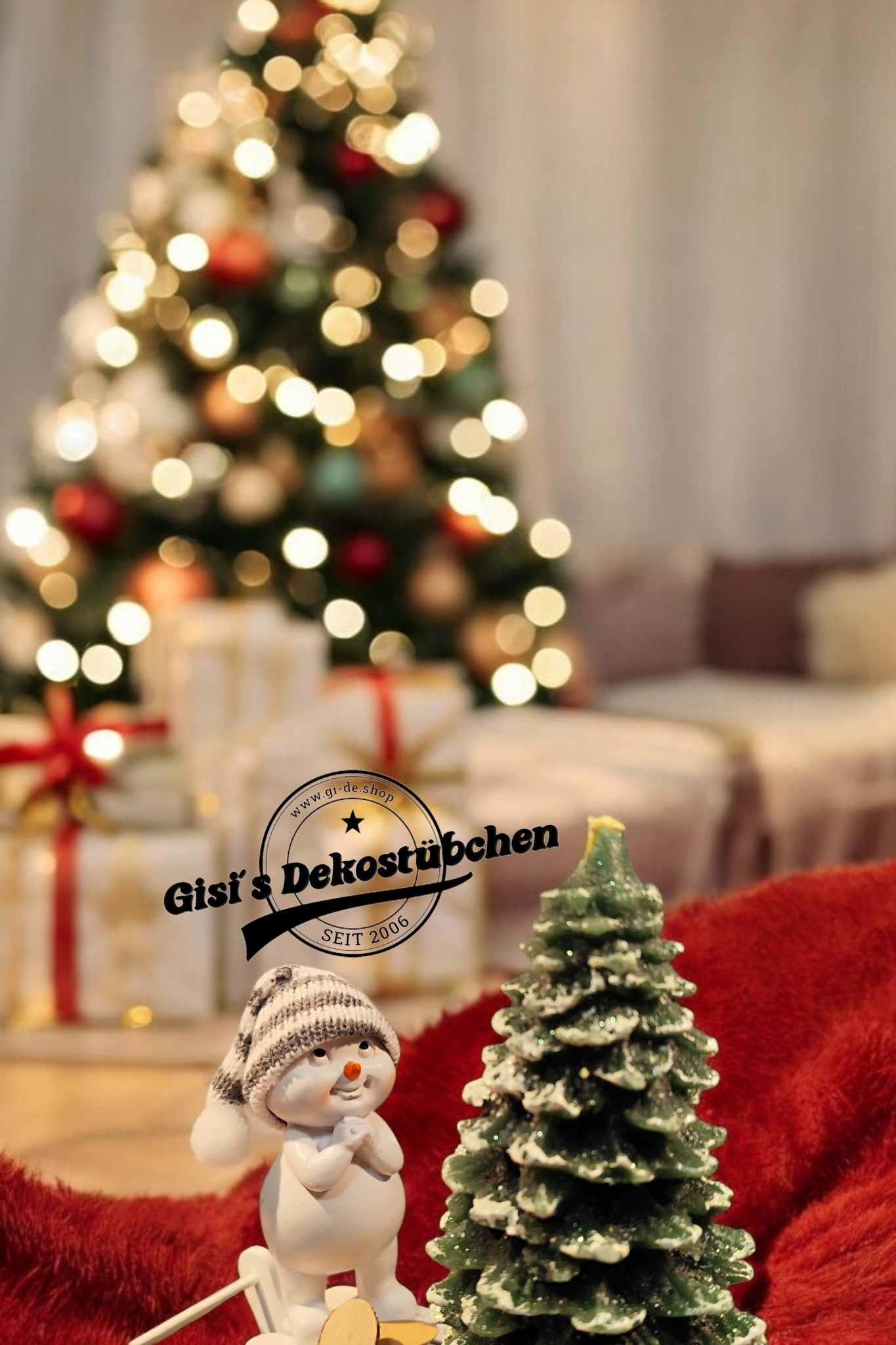 Weihnachtsdeko mit Schlitten, Schneemann, Tannebaumkerze und Holzscheiben Grün